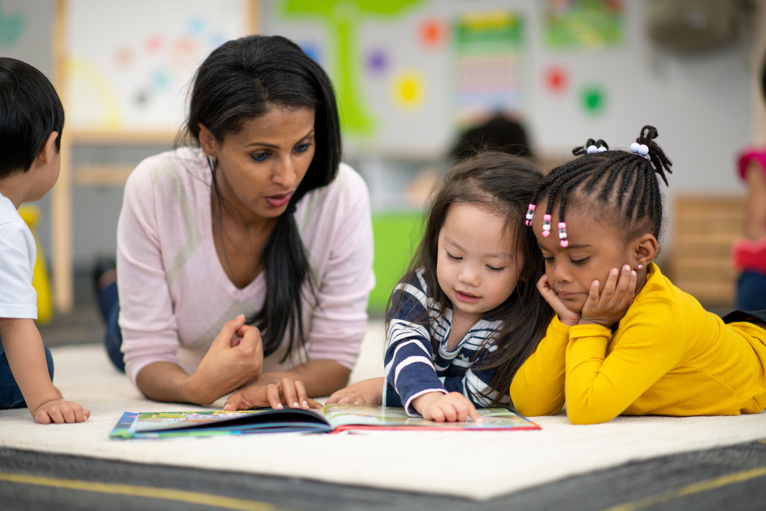 Preschool teacher reading with students